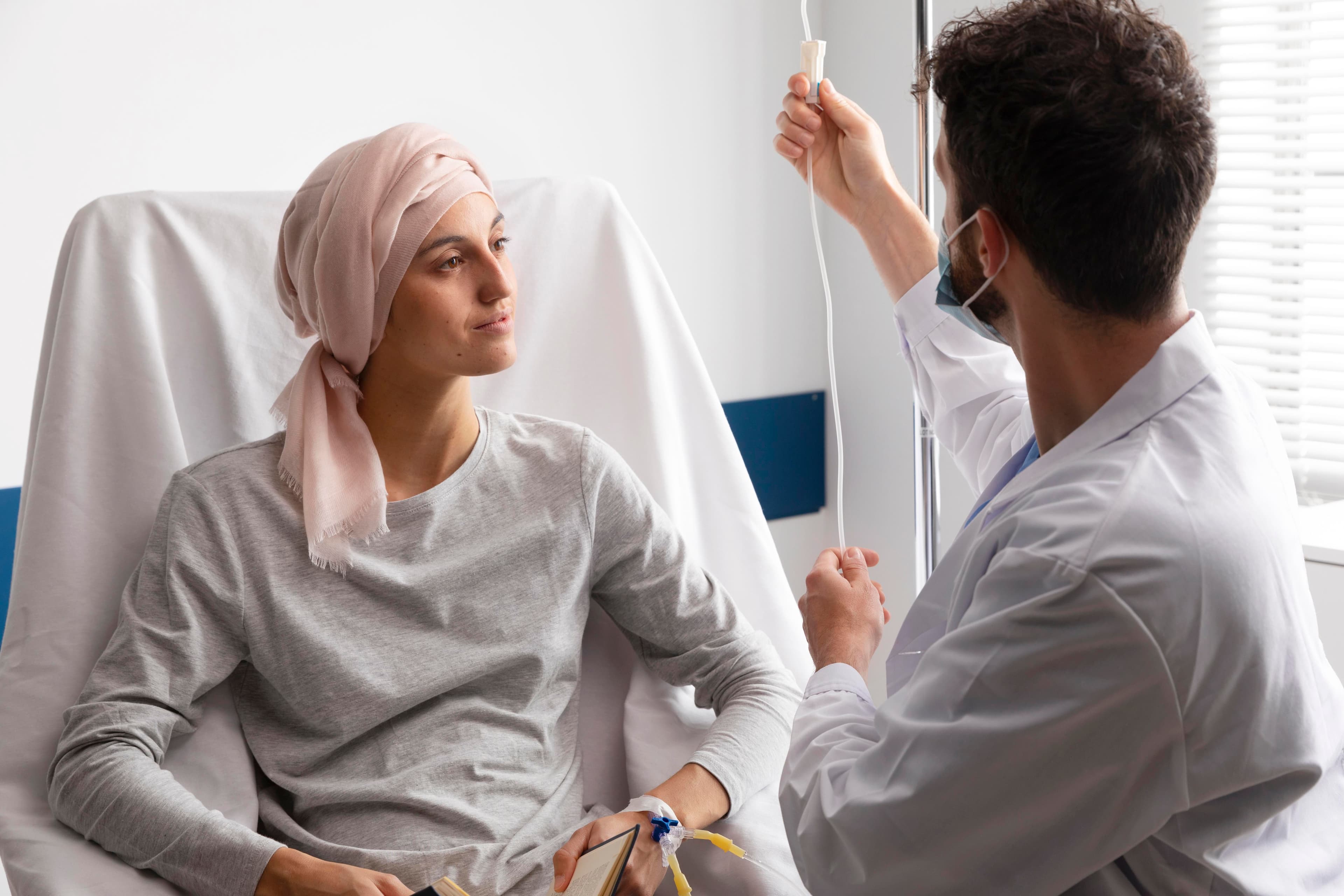 Sarcoma: a doctor is giving an iv to a patient in a hospital bed .
