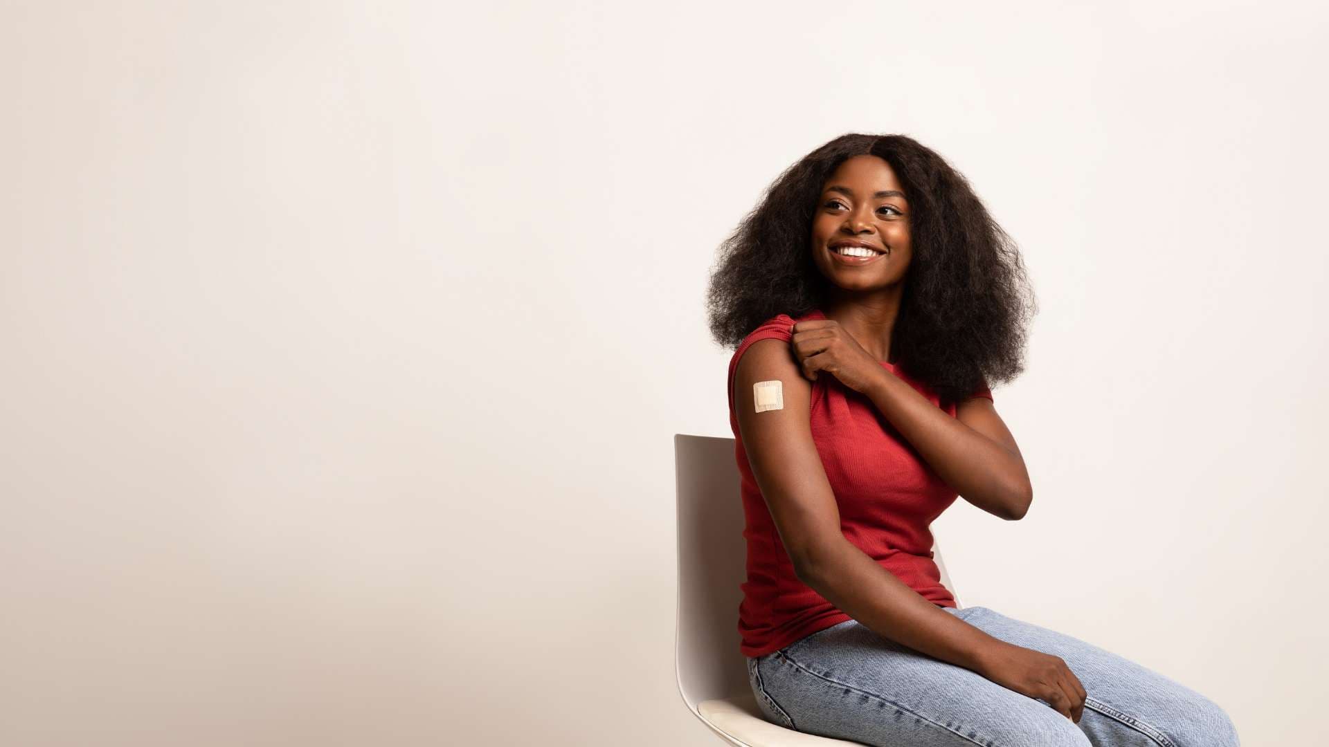 a woman is sitting on a chair with a bandage on her arm .