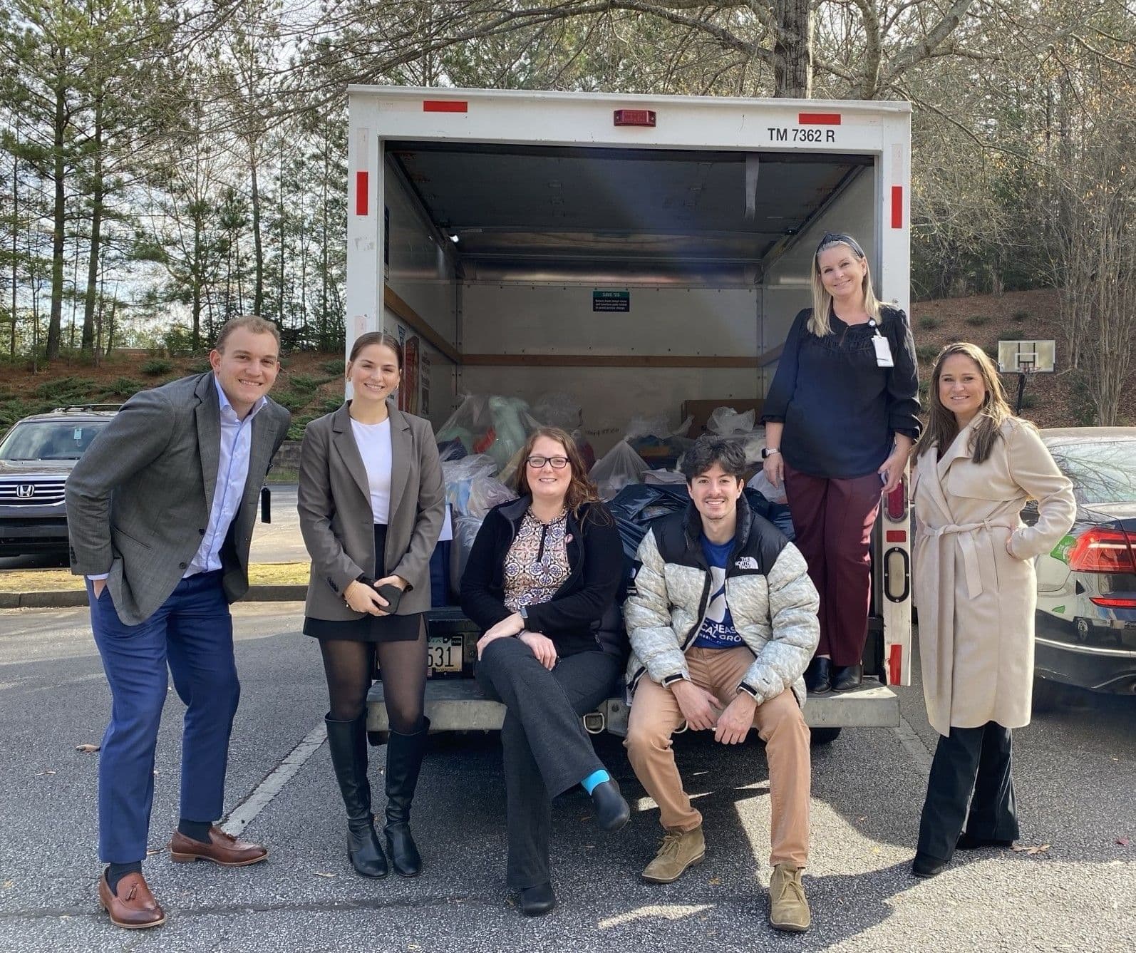 a group of people are posing for a picture in front of a truck .