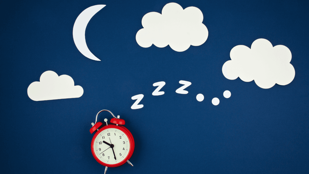 a red alarm clock on a blue background with clouds and a crescent moon