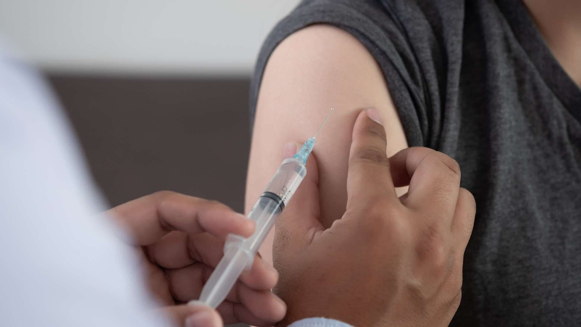 a person is getting an injection in their arm .