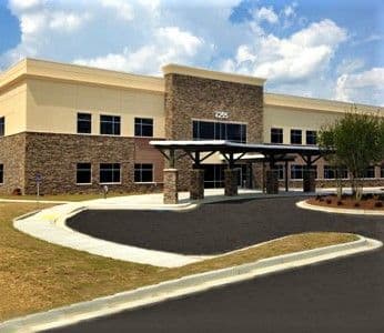 a large building with a lot of windows and a driveway in front of it .