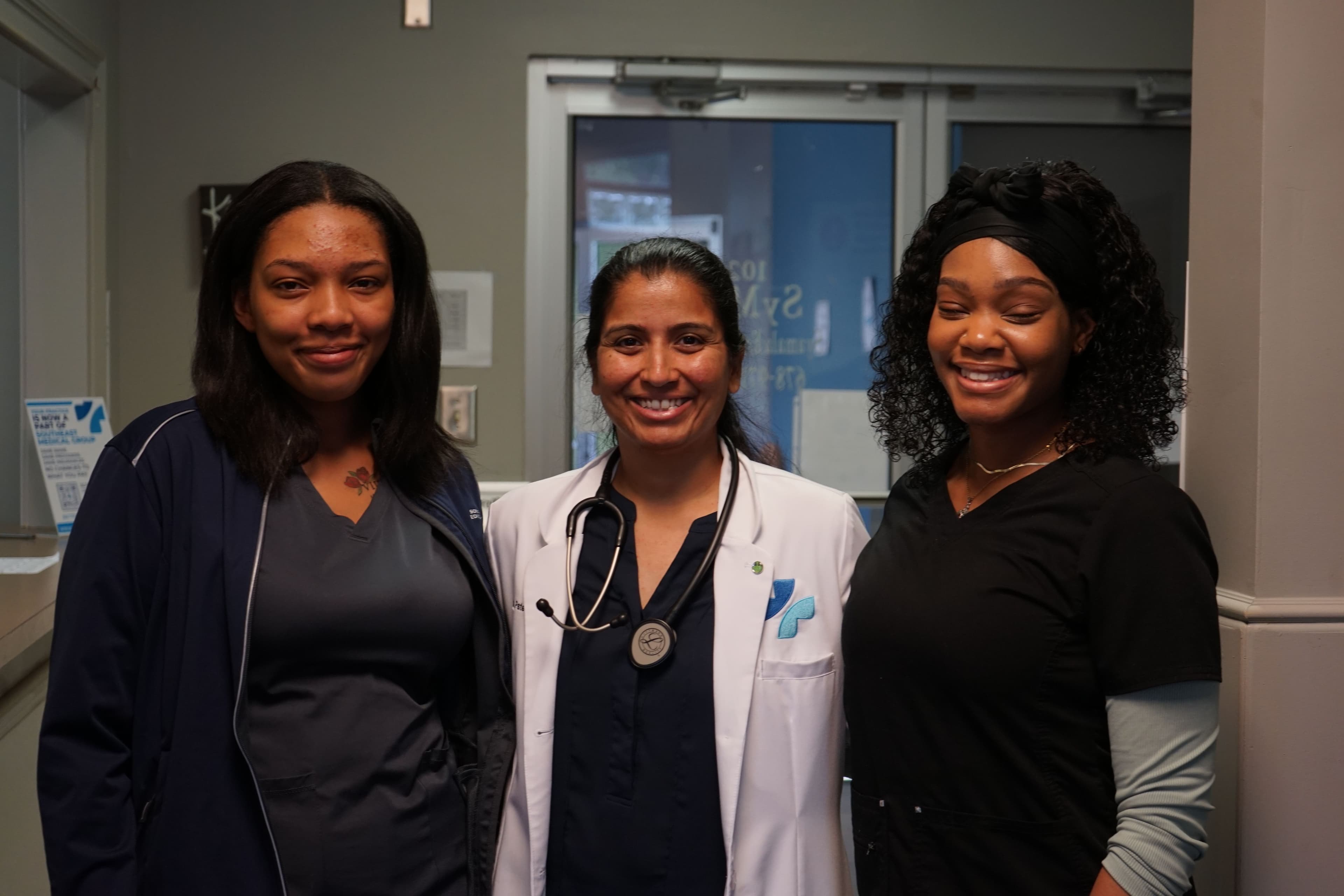 three nurses are posing for a picture together in a hospital .