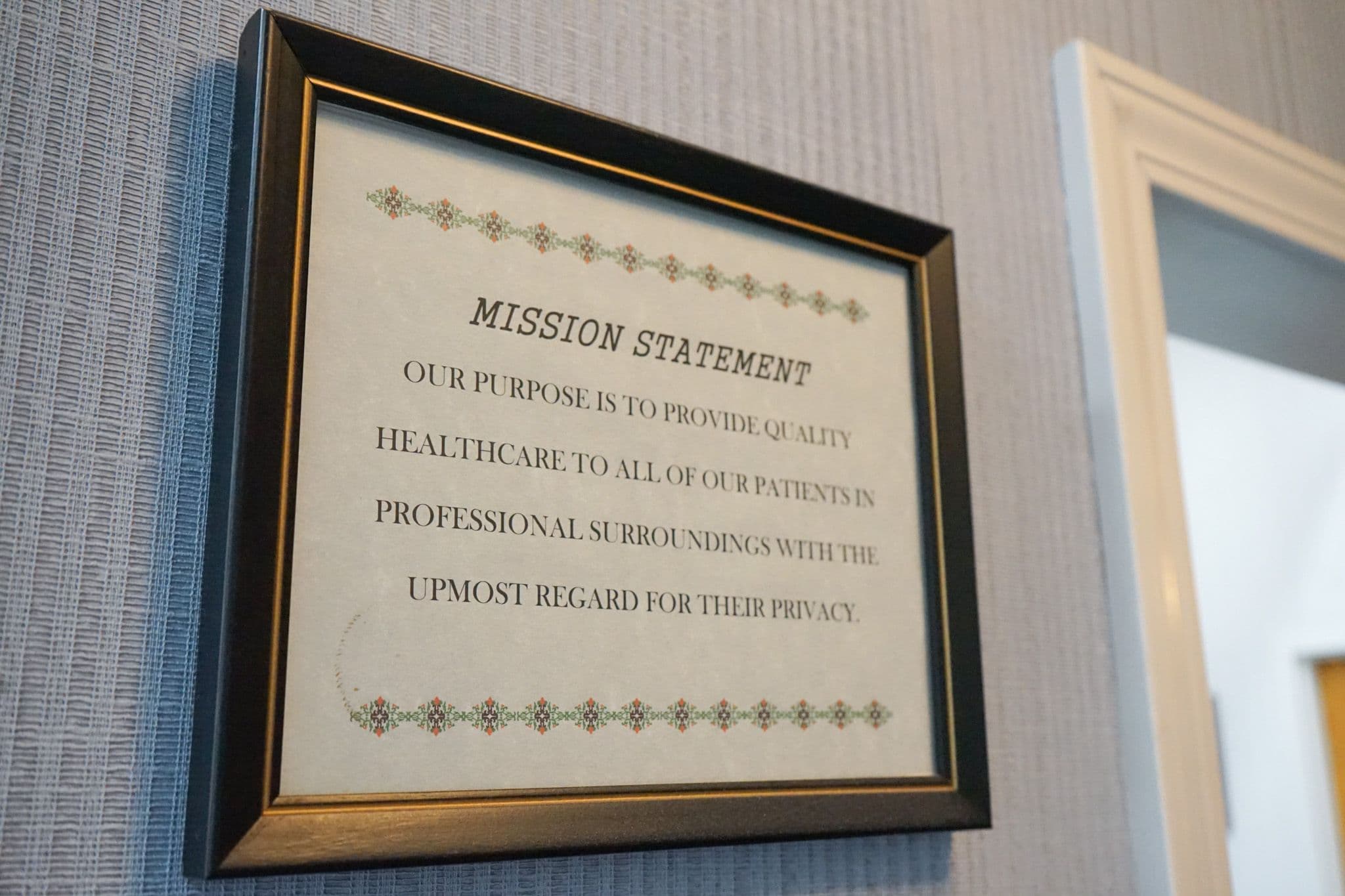 a framed mission statement is hanging on a wall .