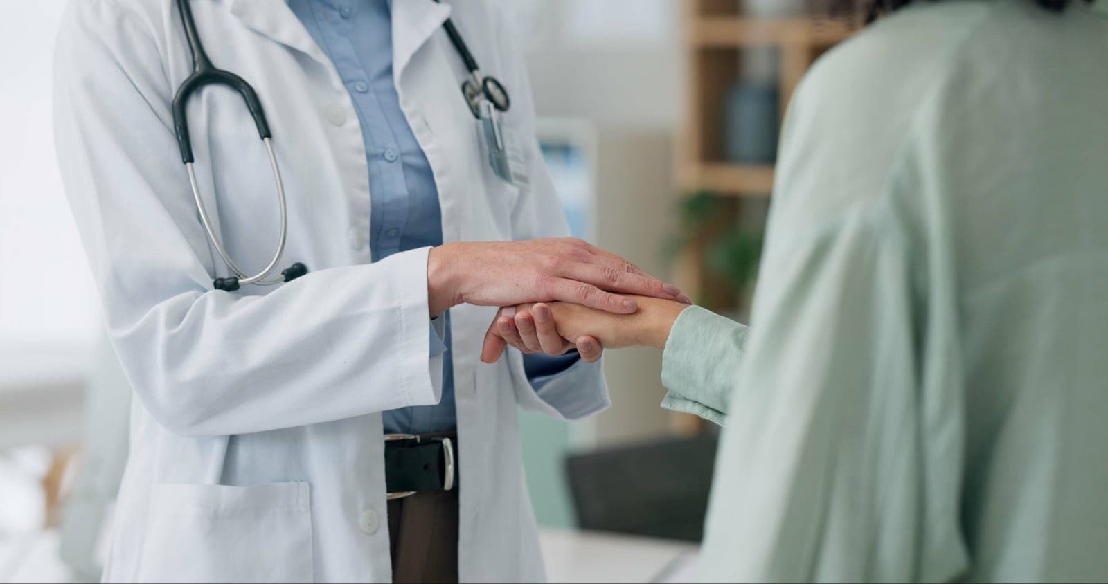 a doctor is holding the hand of a doctor in a hospital .