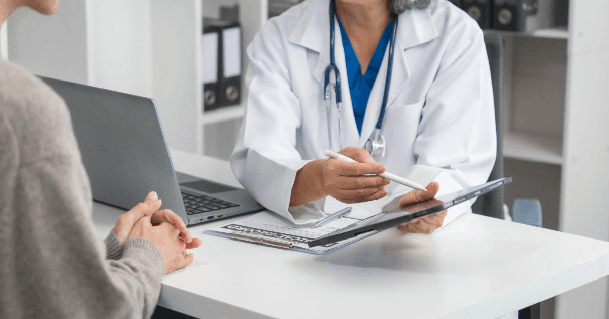 a doctor is talking to a patient while holding a clipboard