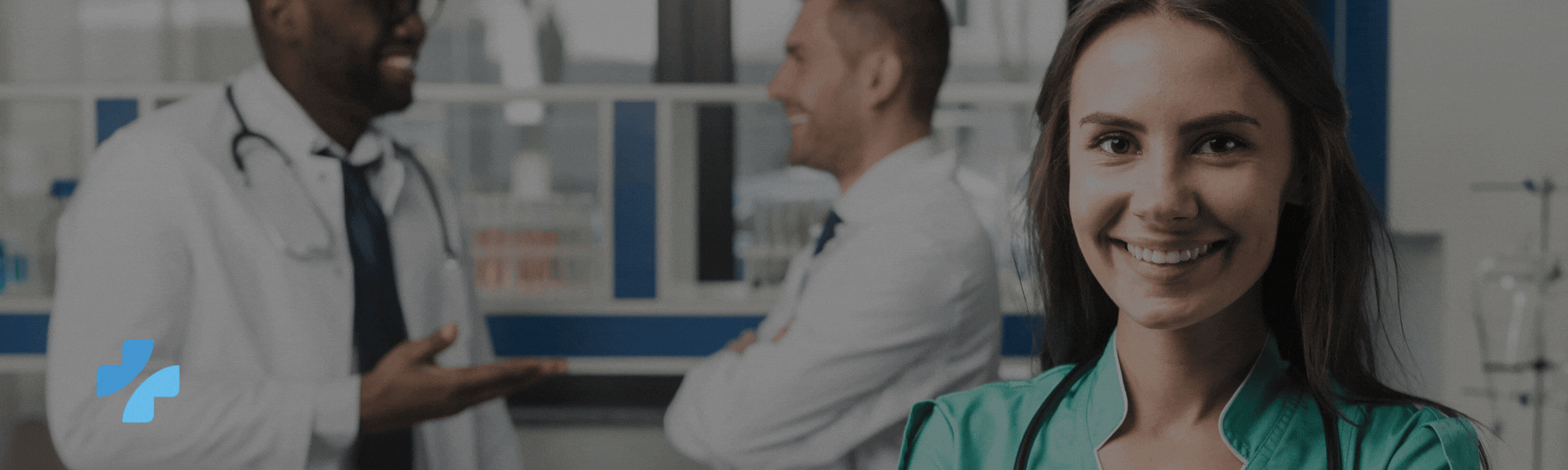 A smiling female medical professional with two doctors in the background and a blue logo.