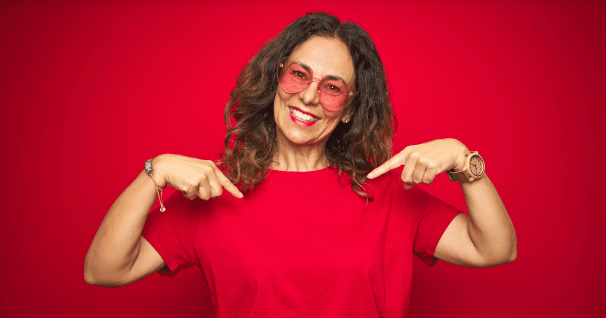 a woman in a red shirt is pointing at herself