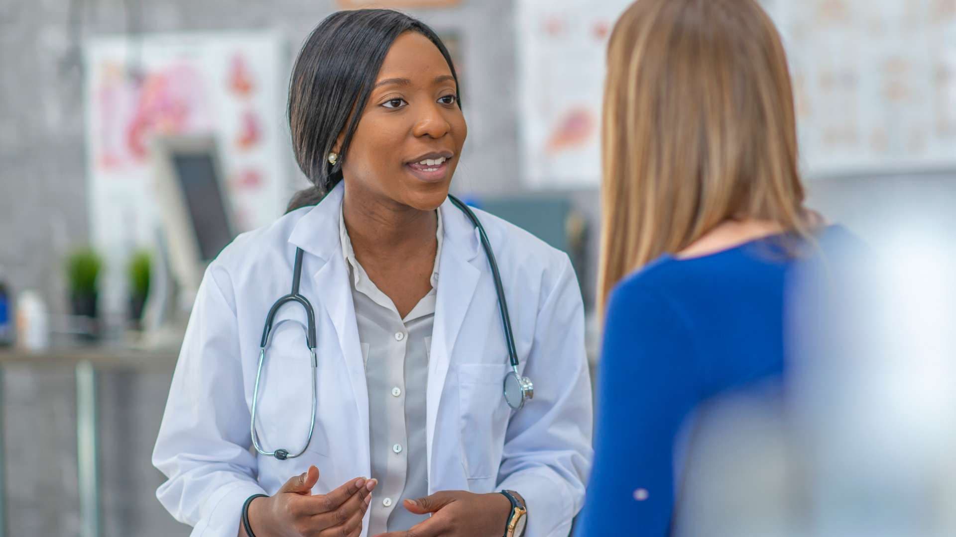 a female doctor is talking to a patient in a hospital .