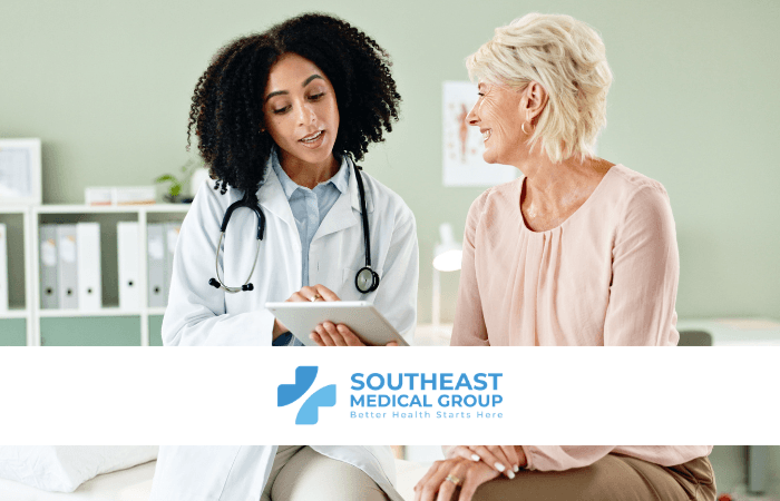A female doctor shows a tablet to a smiling female patient. The Southeast Medical Group logo is displayed below.
