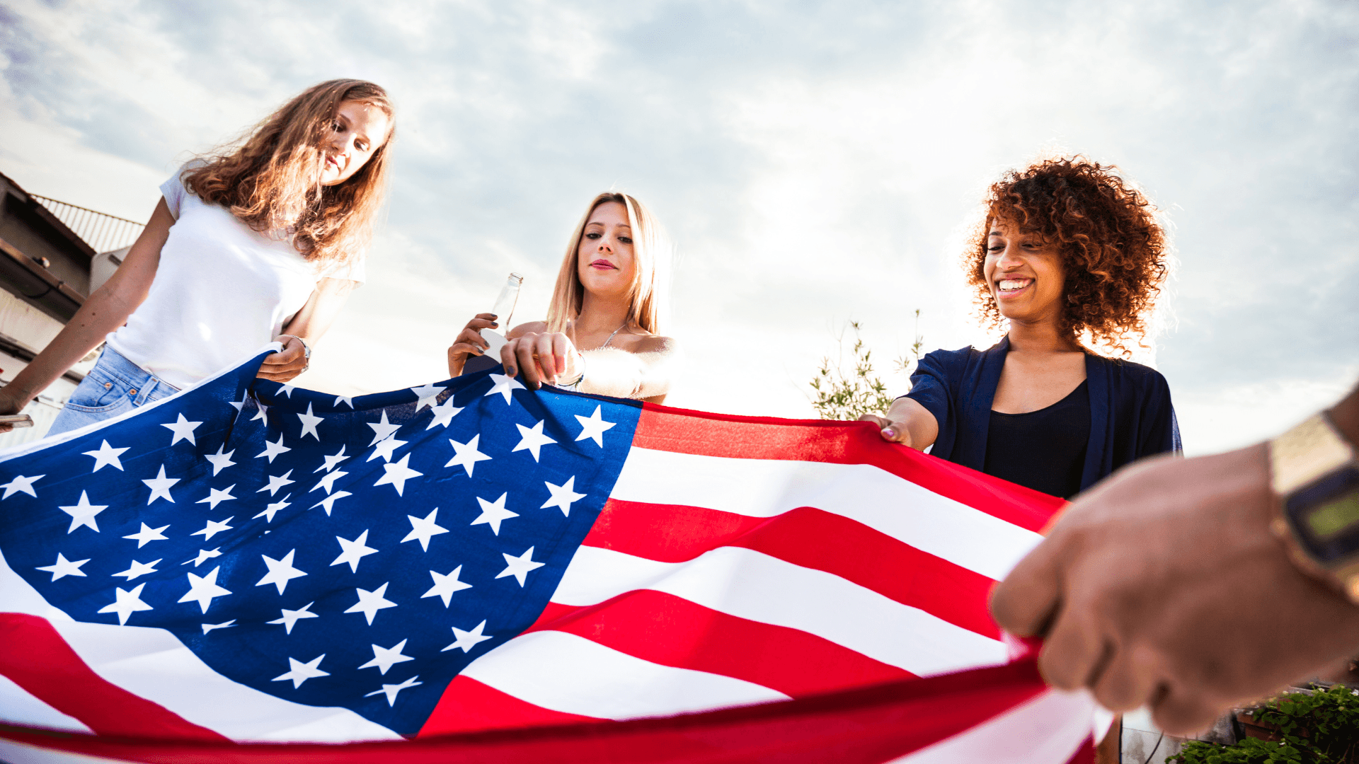 a group of people holding a large american flag