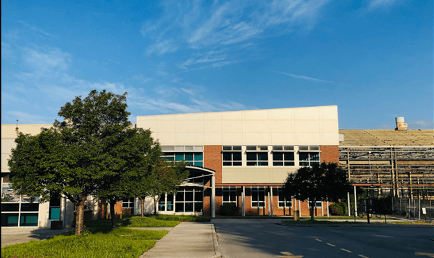 a large building with a lot of windows and trees in front of it