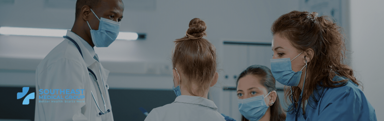 Medical team in masks caring for a young patient, Southeast Medical Group logo.