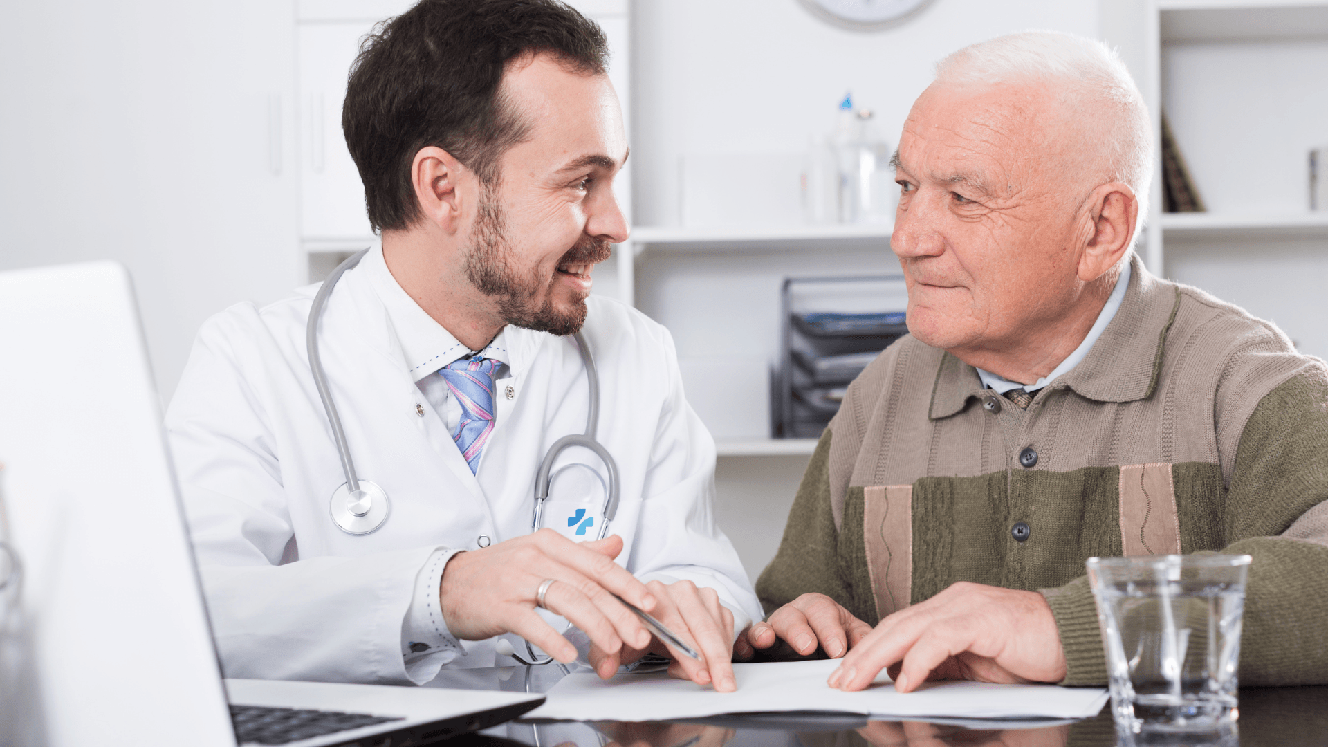 Annual Medicare Wellness Visit: A doctor and an elderly man are looking at a piece of paper
